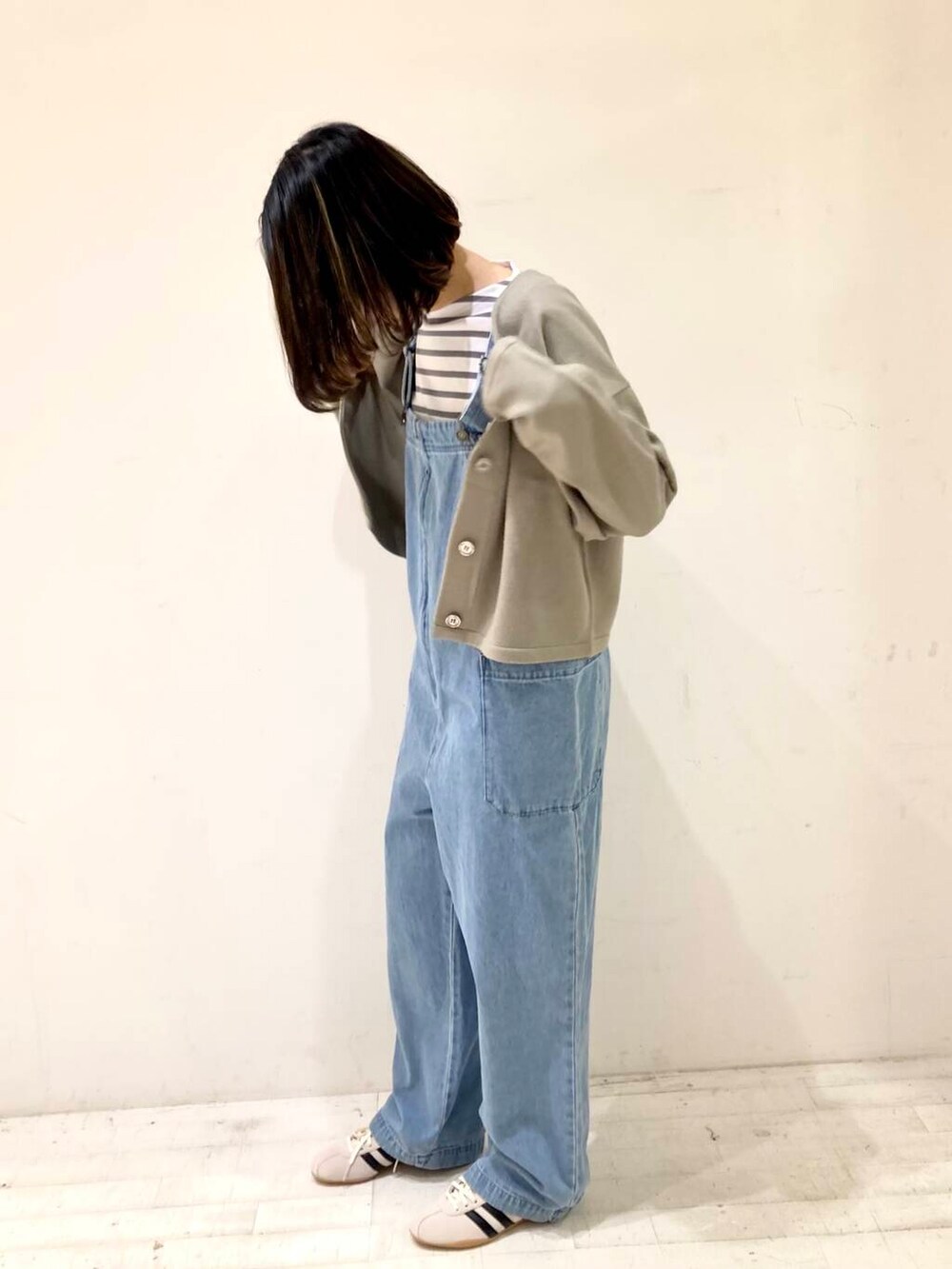 ベージュ系のカーディガン/ボレロ、グレー系のTシャツ/カットソー、ブルー系のサロペット/オーバーオールを着用したレディースの冬コーディネートの5枚目の写真