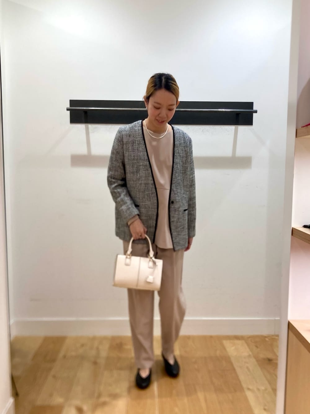 ベージュ系のセットアップ、ブラック系のスーツジャケット、ホワイト系のネックレスを着用したレディースの冬コーディネートの5枚目の写真