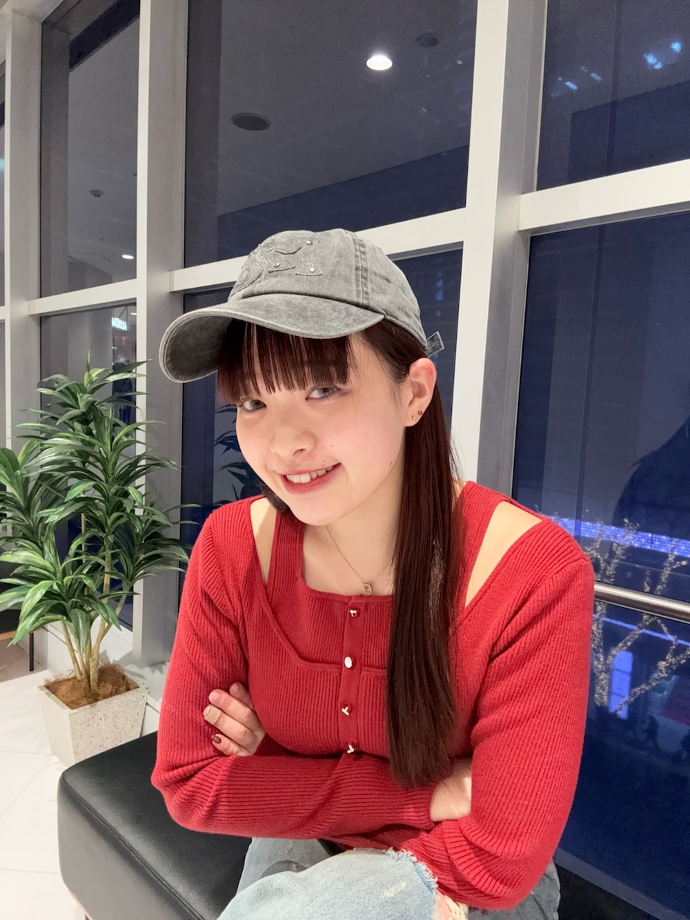 レッド系のニット/セーター、ブルー系のデニムパンツ、ブラック系のブーツを着用したレディースの冬コーディネートの4枚目の写真