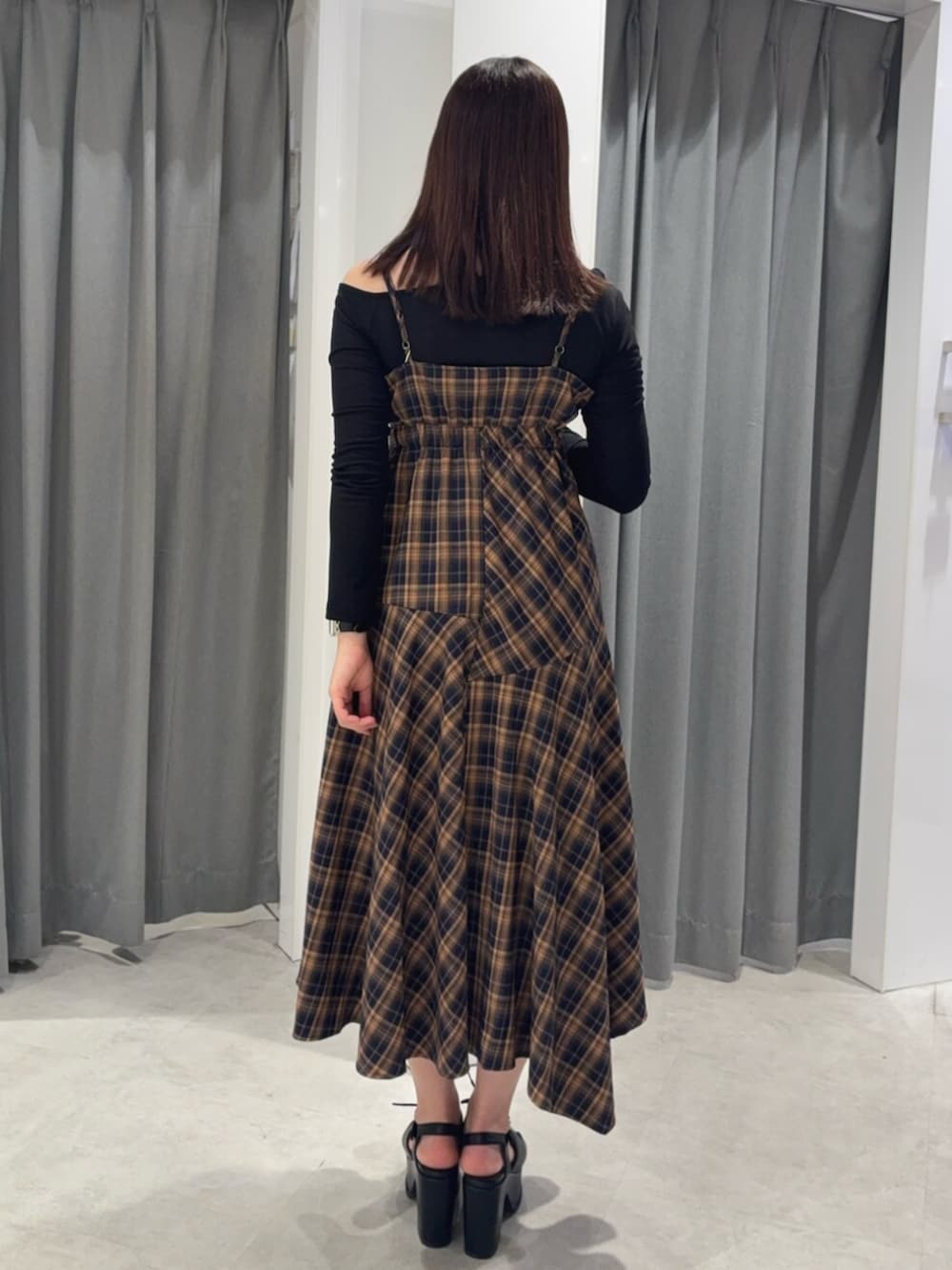オレンジ系のワンピース、ブラック系のTシャツ/カットソー、ブラック系のサンダルを着用したレディースの春コーディネートの4枚目の写真
