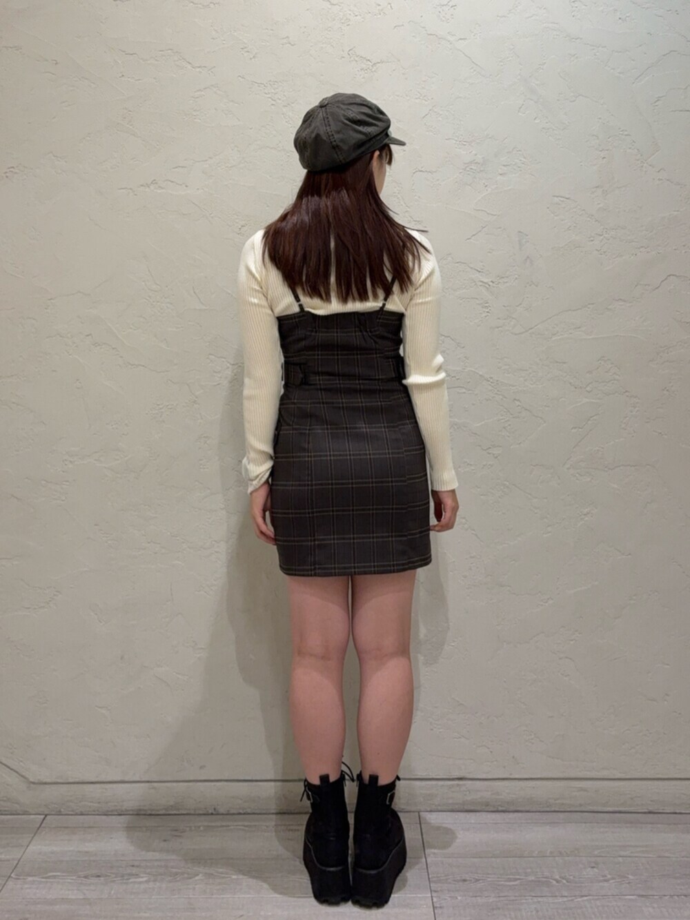 ブラック系のブーツ、ブラウン系のワンピース、ホワイト系のニット/セーターを着用したレディースの秋コーディネートの3枚目の写真