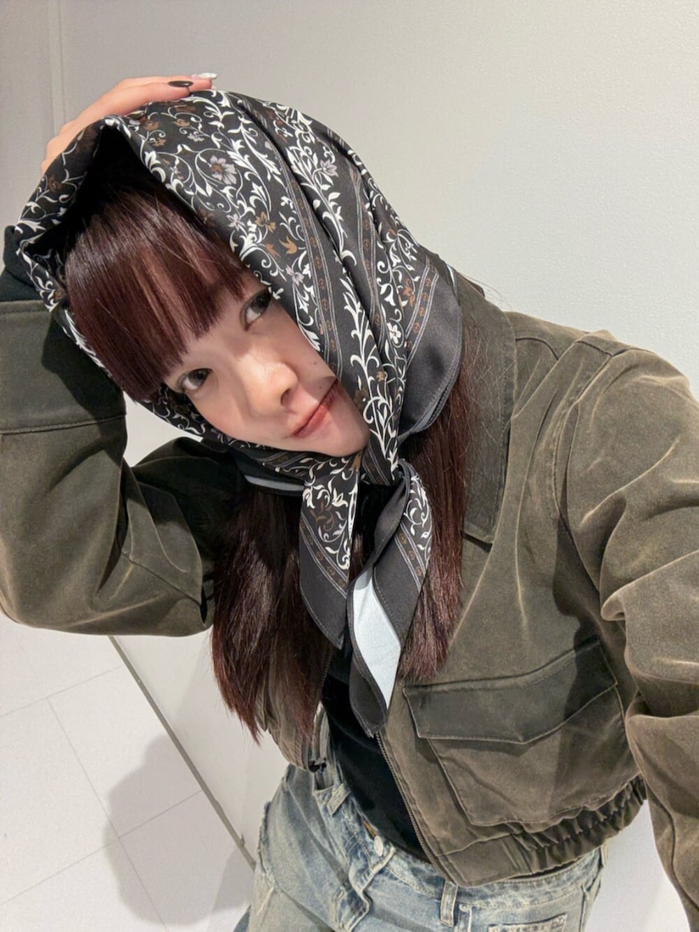 ブラウン系のローファー、ブラウン系のブルゾン、ブルー系のデニムパンツを着用したレディースの秋コーディネートの4枚目の写真