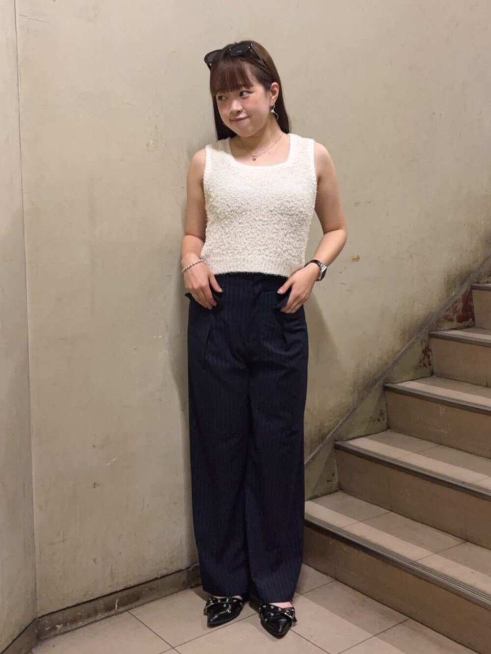 ブルー系のその他パンツ、ホワイト系のニット/セーター、ブラック系のパンプスを着用したレディースの夏コーディネートの2枚目の写真