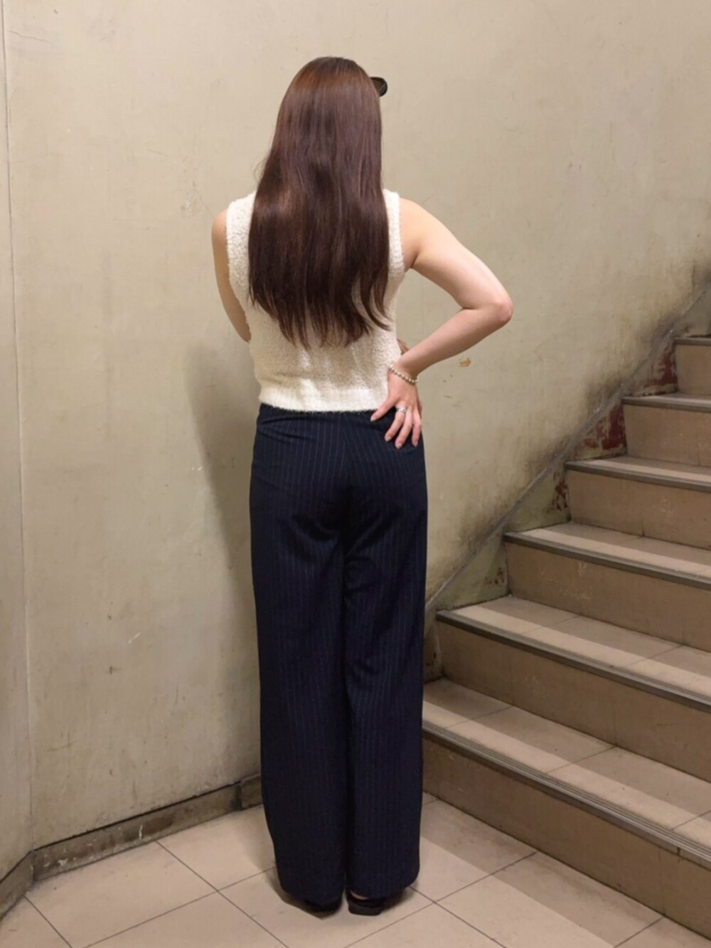 ブルー系のその他パンツ、ホワイト系のニット/セーター、ブラック系のパンプスを着用したレディースの夏コーディネートの4枚目の写真