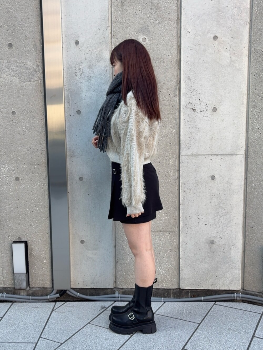 ブラック系のその他パンツ、ホワイト系のニット/セーター、ブラック系のブーツを着用したレディースの秋コーディネートの2枚目の写真