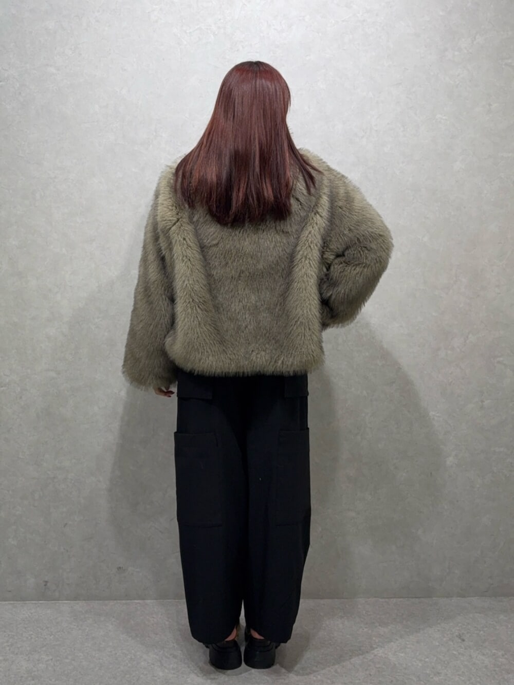 グレー系のブルゾン、ブラック系のカーゴパンツ、ブラウン系のローファーを着用したレディースの夏コーディネートの3枚目の写真