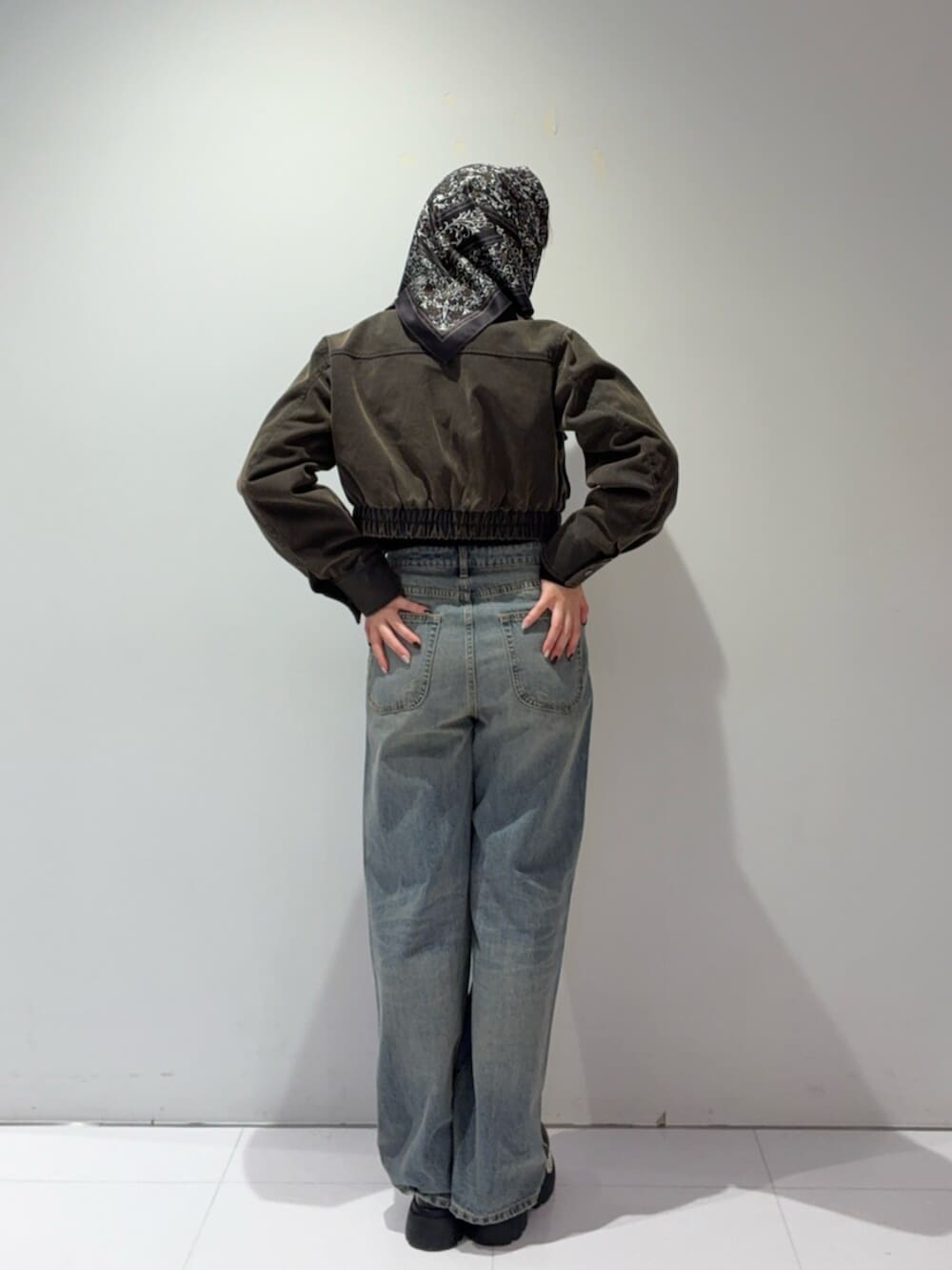 ブラウン系のローファー、ブラウン系のブルゾン、ブルー系のデニムパンツを着用したレディースの秋コーディネートの3枚目の写真