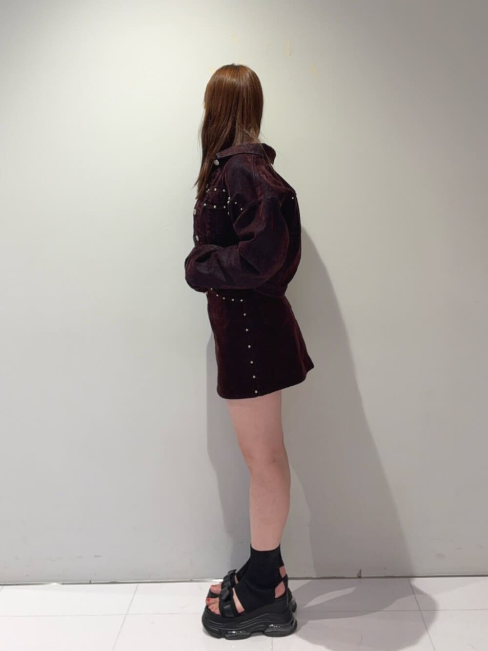 ブラック系のサンダル、レッド系のデニムジャケット、レッド系のスカートを着用したレディースの夏コーディネートの2枚目の写真