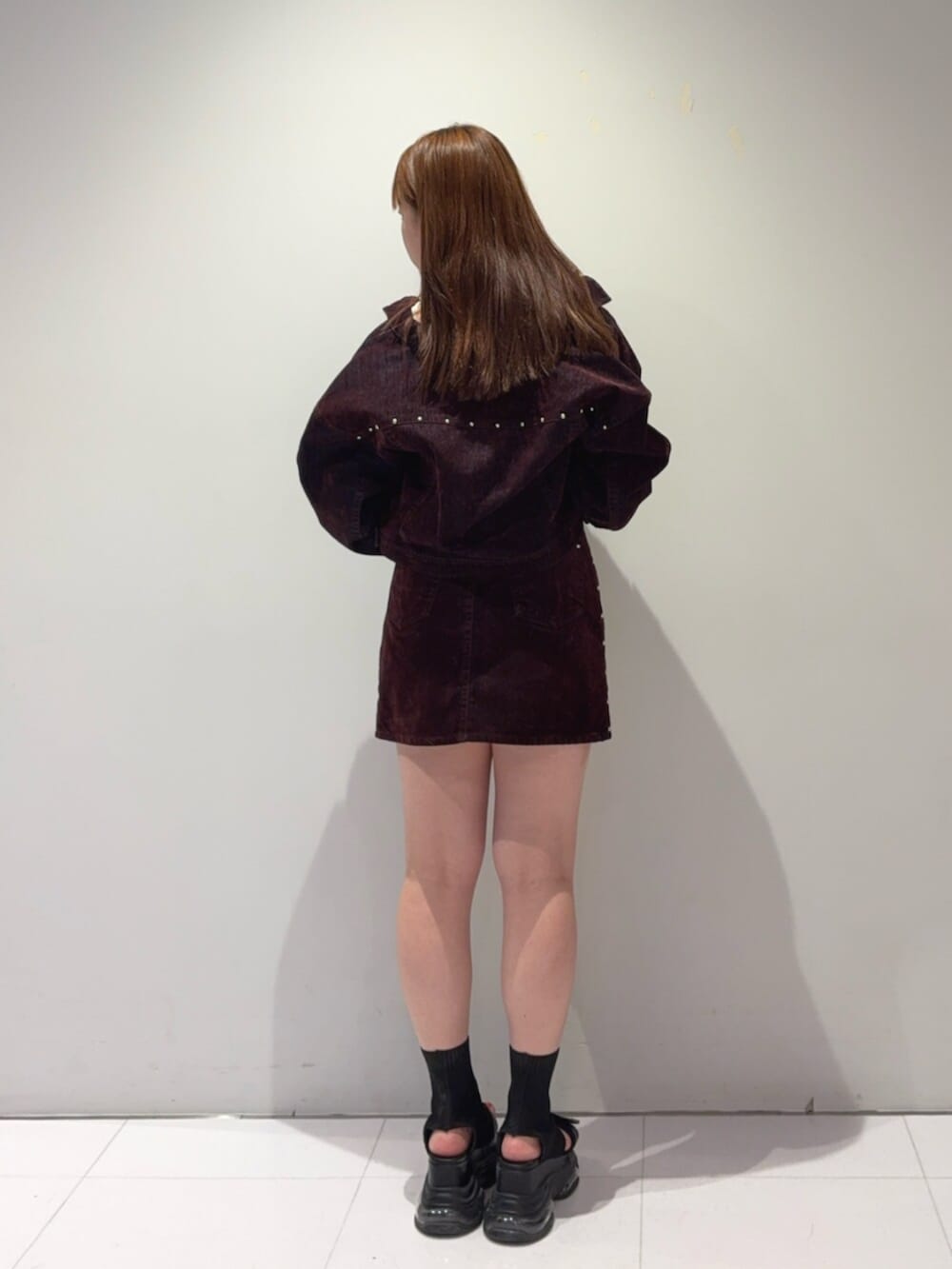 ブラック系のサンダル、レッド系のデニムジャケット、レッド系のスカートを着用したレディースの夏コーディネートの3枚目の写真