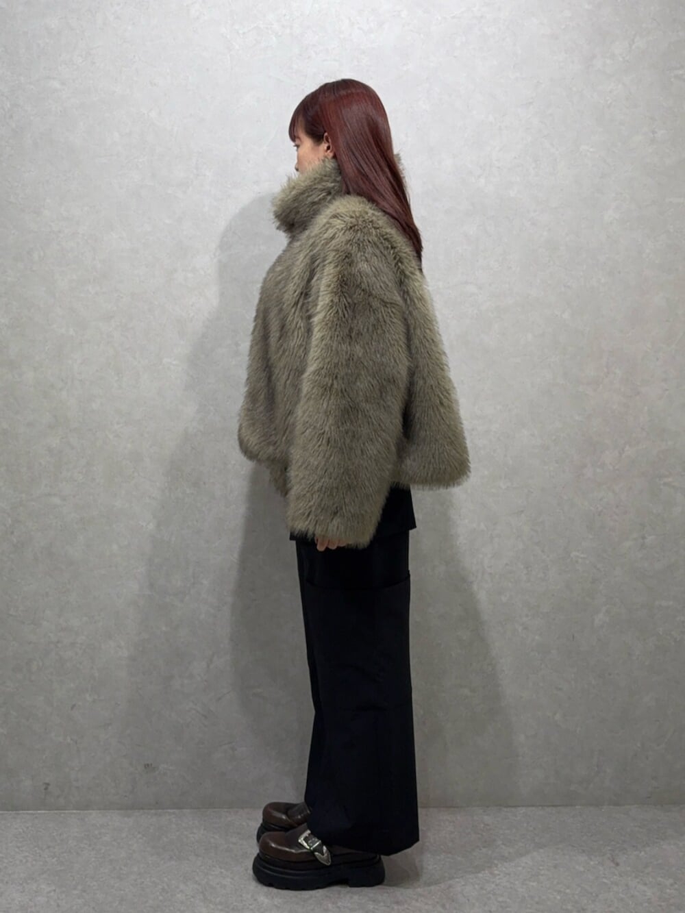 グレー系のブルゾン、ブラック系のカーゴパンツ、ブラウン系のローファーを着用したレディースの夏コーディネートの2枚目の写真