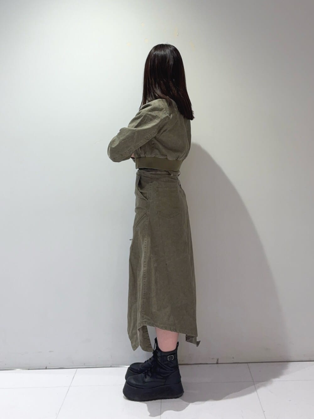 ブラック系のブーツ、グリーン系のブルゾン、グリーン系のスカートを着用したレディースの春コーディネートの2枚目の写真