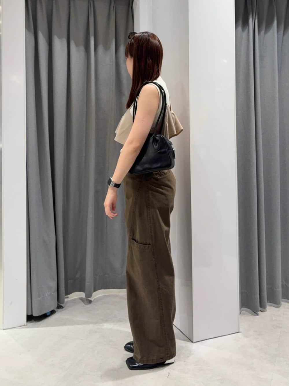 ブラック系のパンプス、ホワイト系のタンクトップ、ブラウン系のその他パンツを着用したレディースの夏コーディネートの2枚目の写真