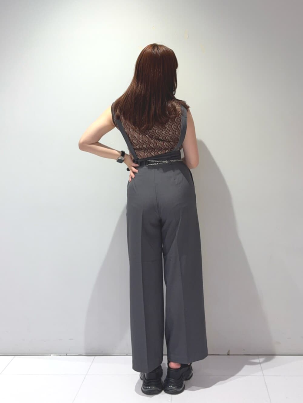 ブラック系のサンダル、ブラウン系のタンクトップ、グレー系のスラックスを着用したレディースの夏コーディネートの3枚目の写真