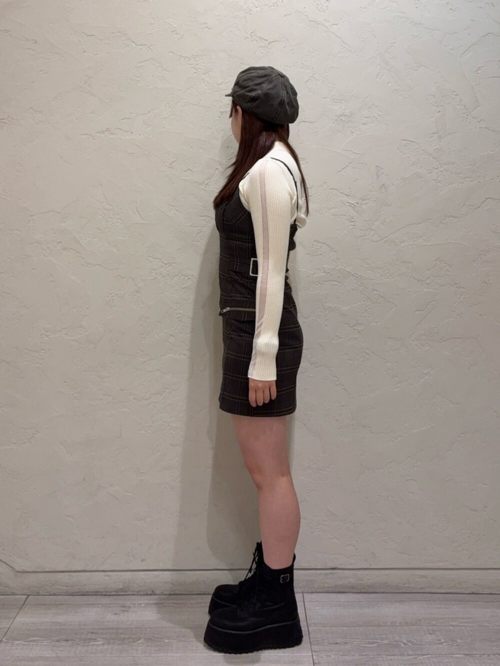 ブラック系のブーツ、ブラウン系のワンピース、ホワイト系のニット/セーターを着用したレディースの秋コーディネートの2枚目の写真