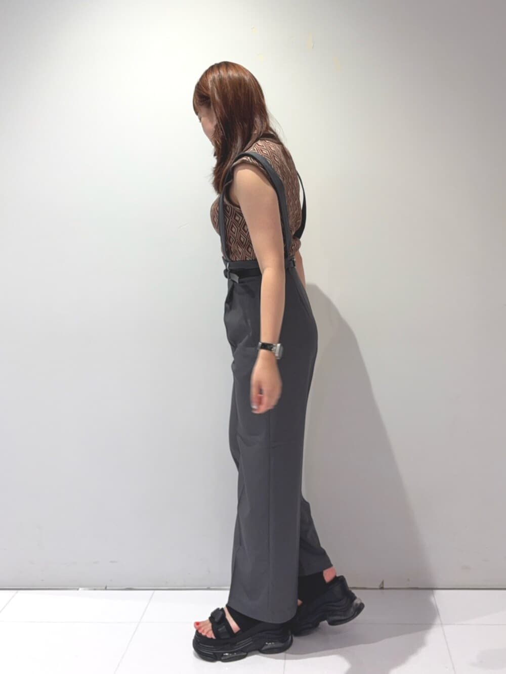 ブラック系のサンダル、ブラウン系のタンクトップ、グレー系のスラックスを着用したレディースの夏コーディネートの2枚目の写真