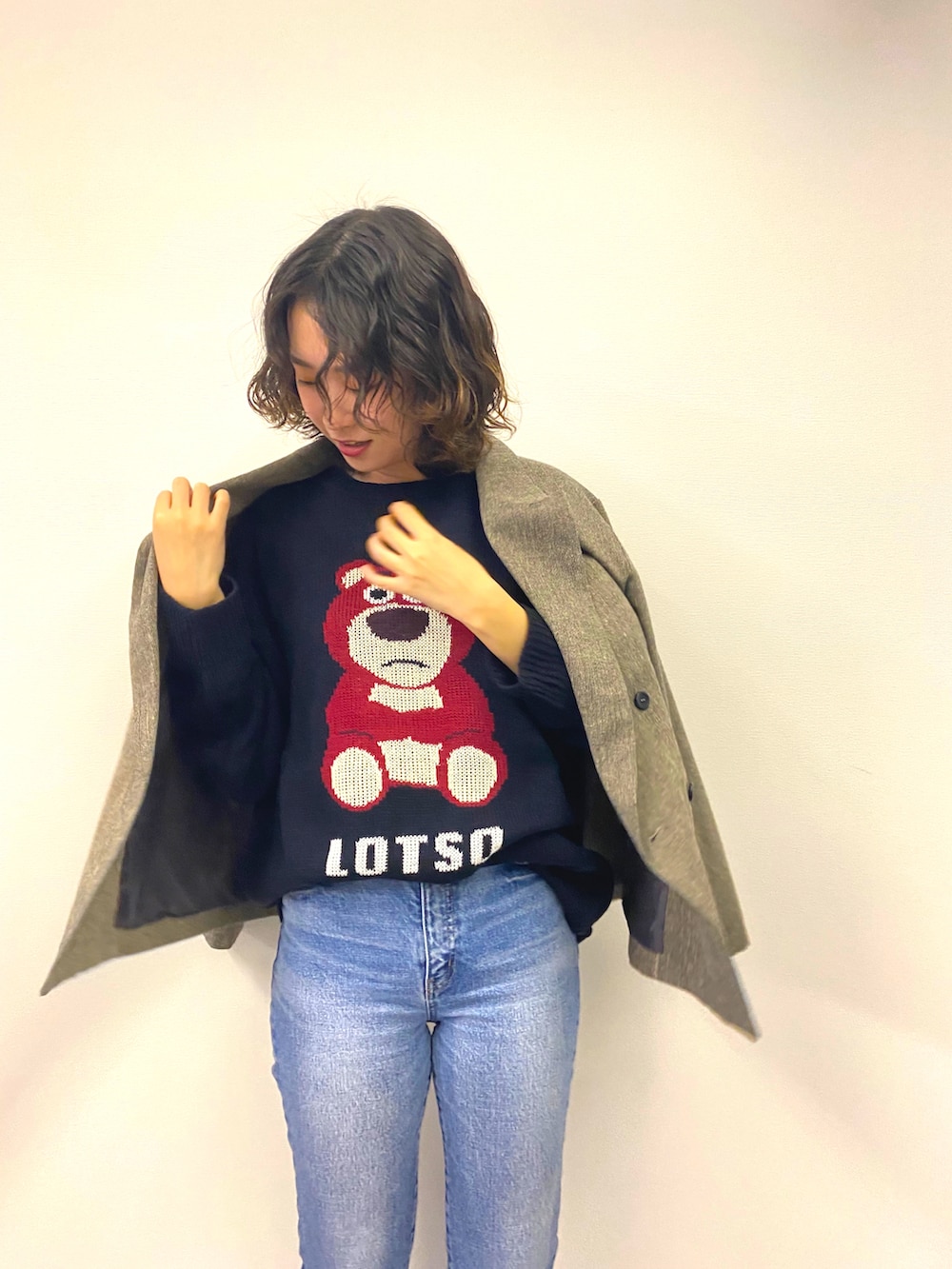 ブラック系のブーツ、ブルー系のデニムパンツ、ブルー系のニット/セーターを着用したレディースの秋コーディネートの2枚目の写真