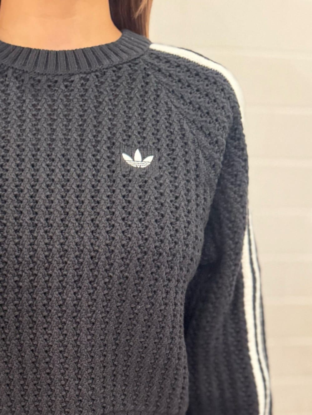 ブラック系のニット/セーター、ブラック系のスカート、ブラウン系のスニーカーを着用したレディースの冬コーディネートの2枚目の写真