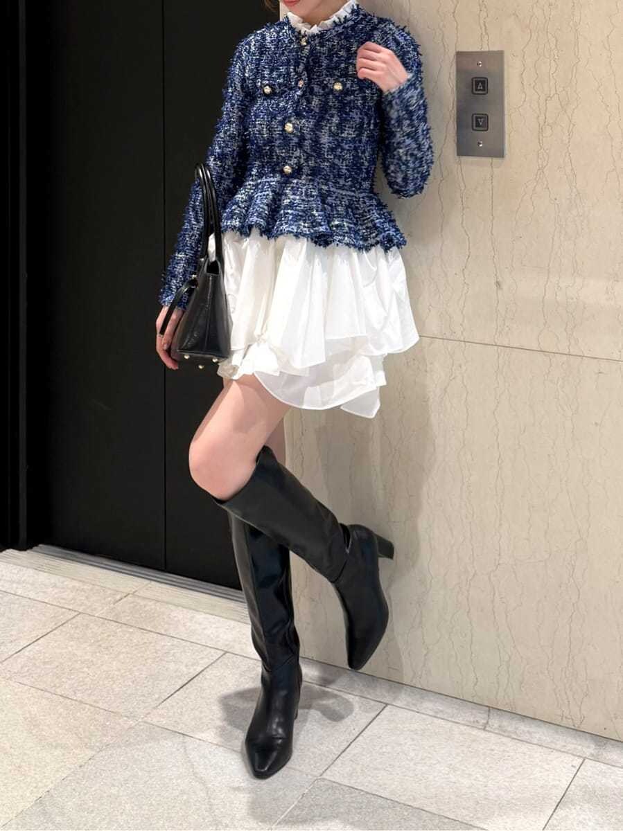 ブルー系のワンピース、ブラック系のブーツ、ブラック系のボストンバッグを着用したレディースの秋コーディネートの5枚目の写真
