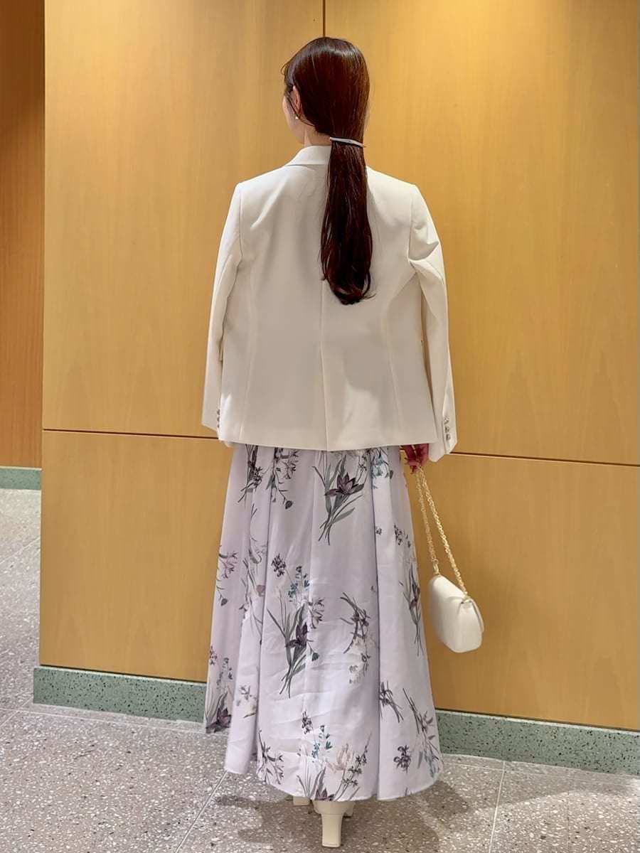 ホワイト系のテーラードジャケット、パープル系のワンピース、ホワイト系のショルダーバッグを着用したレディースの春コーディネートの3枚目の写真