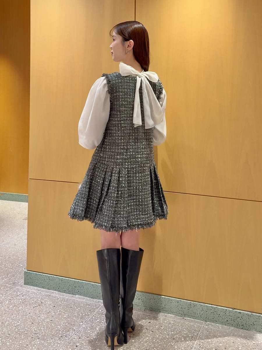 ブラック系のブーツ、グレー系のワンピース、ブラック系のハンドバッグを着用したレディースの冬コーディネートの3枚目の写真