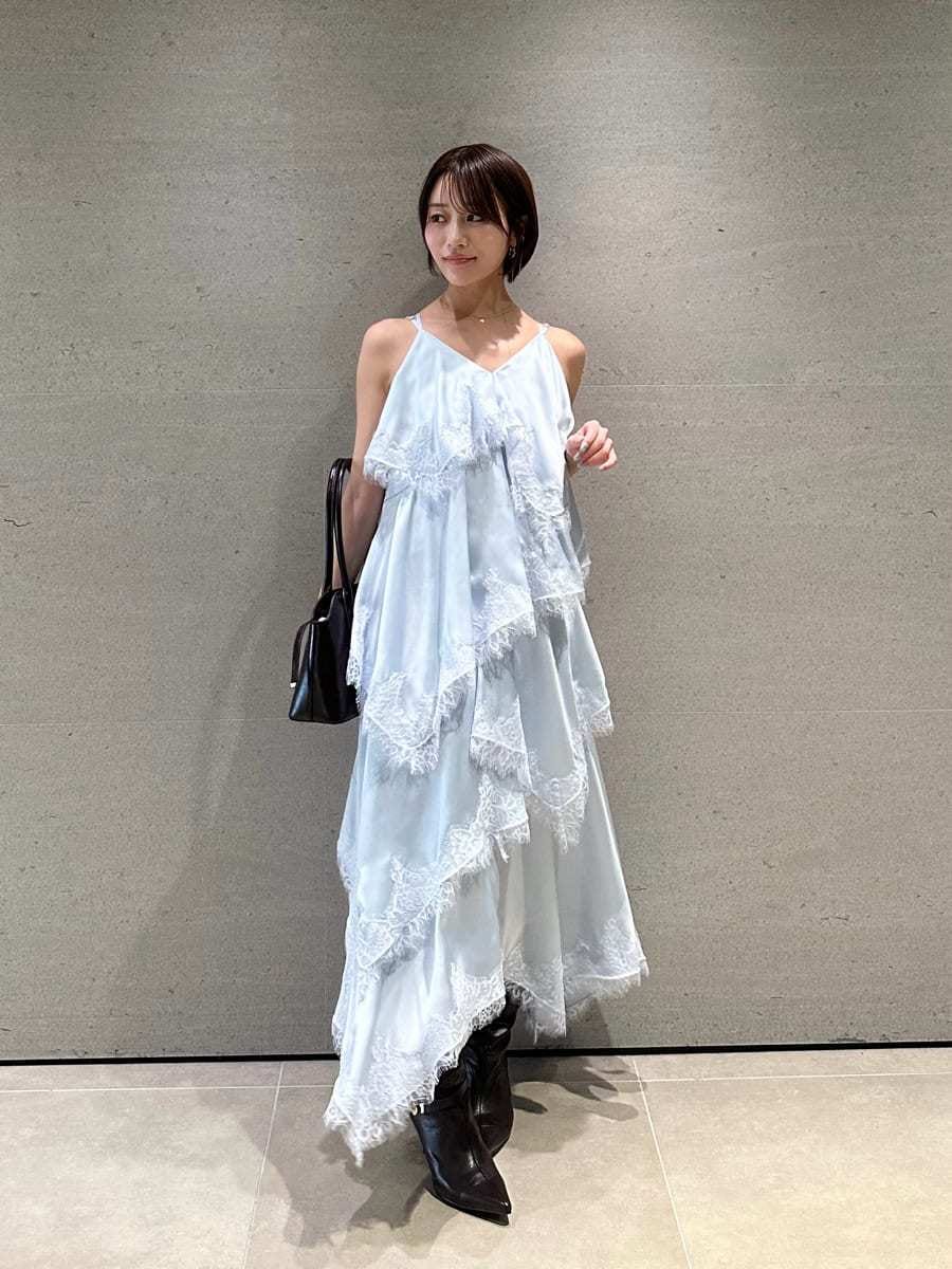 ブルー系のワンピース、ブラウン系のブーツ、ブラウン系のボストンバッグを着用したレディースの夏コーディネートの2枚目の写真