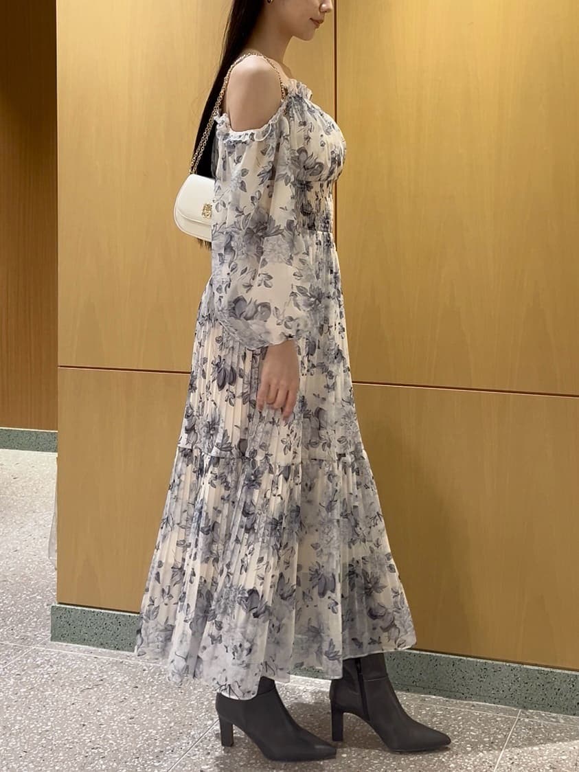 グレー系のブーツ、イエロー系のワンピース、ホワイト系のショルダーバッグを着用したレディースの冬コーディネートの5枚目の写真