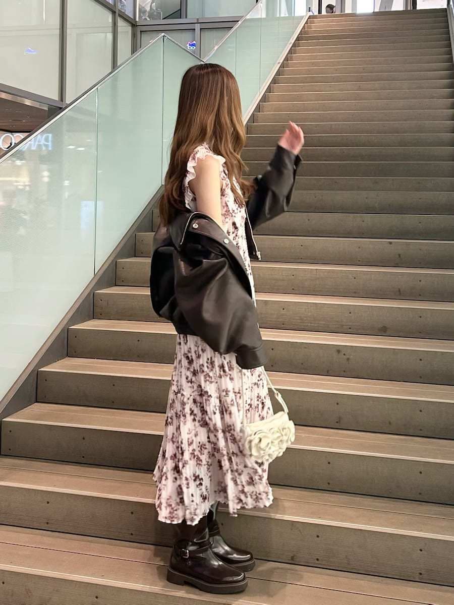 ピンク系のワンピース、ブラウン系のブルゾン、ホワイト系のハンドバッグを着用したレディースの春コーディネートの4枚目の写真