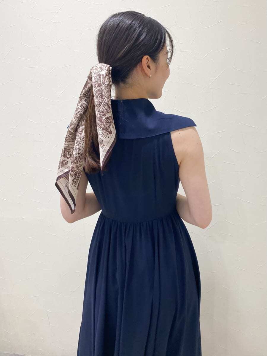 ブルー系のワンピース、ベージュ系のハンドバッグ、ホワイト系のパンプスを着用したレディースの夏コーディネートの5枚目の写真