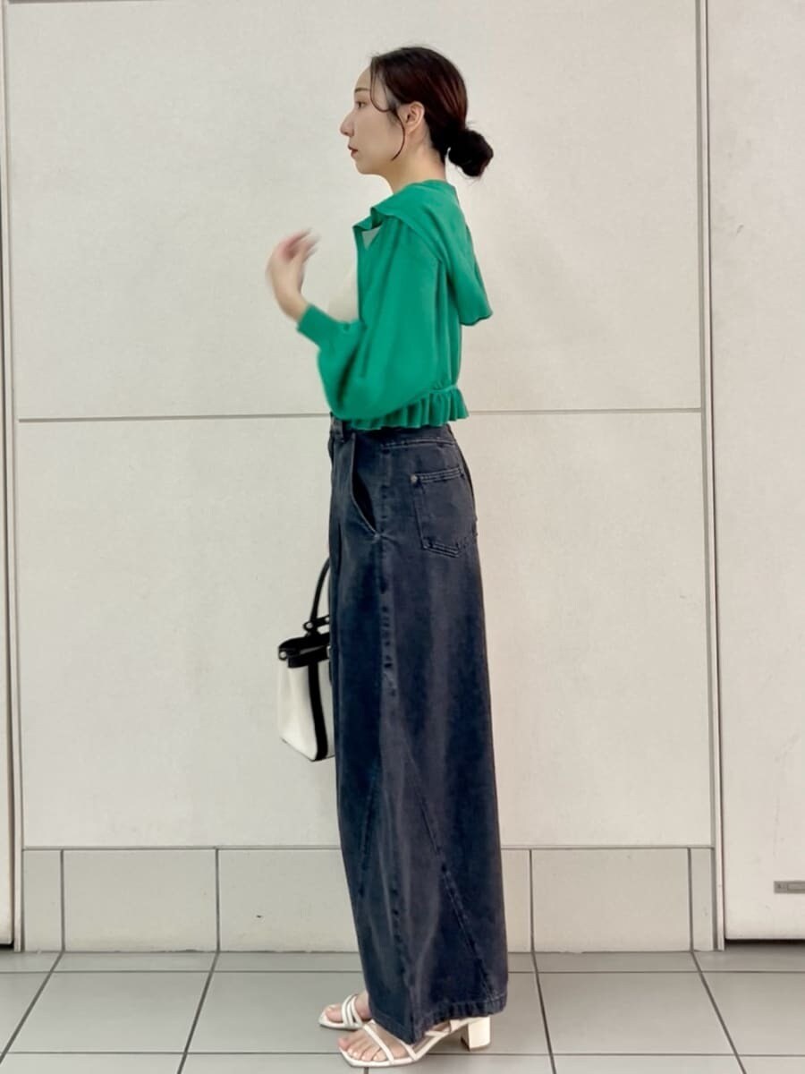 ブラック系のデニムパンツ、ベージュ系のニット/セーター、ブラック系のハンドバッグを着用したレディースの夏コーディネートの3枚目の写真