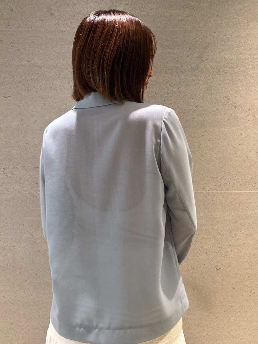 ブルー系のテーラードジャケット、ホワイト系のスカート、ホワイト系のショルダーバッグを着用したレディースの夏コーディネートの6枚目の写真