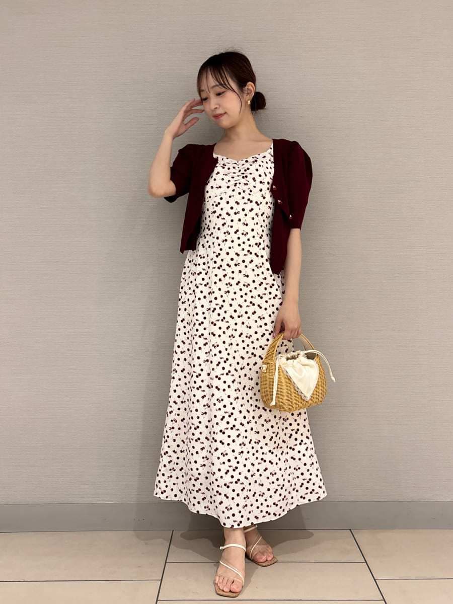 ホワイト系のワンピース、ホワイト系のかごバッグ、レッド系のカーディガン/ボレロを着用したレディースの春コーディネートの4枚目の写真