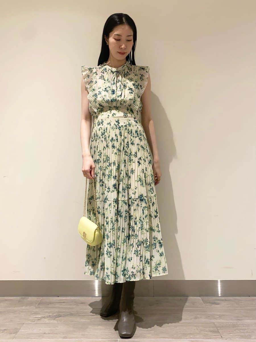 グリーン系のワンピース、ホワイト系のテーラードジャケット、イエロー系のショルダーバッグを着用したレディースの冬コーディネートの5枚目の写真