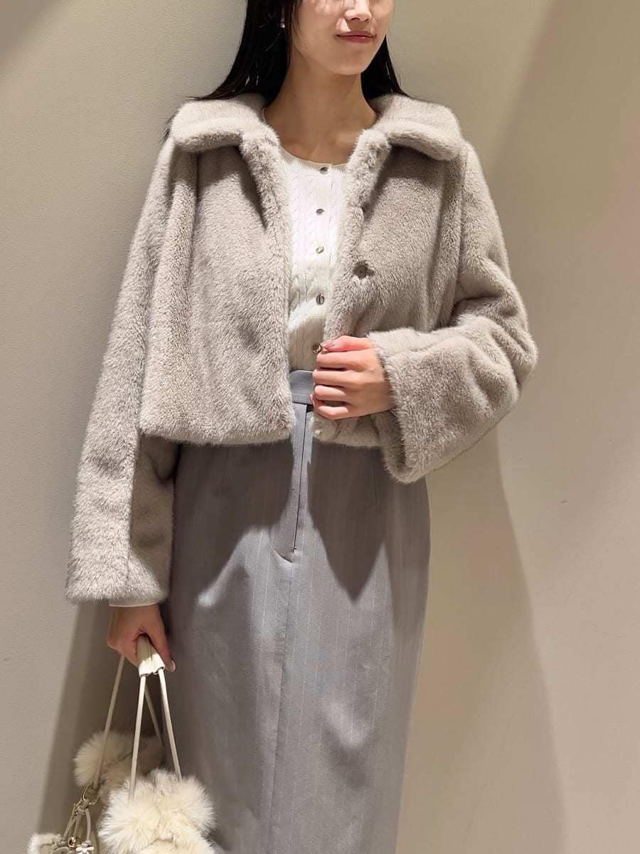 ベージュ系のステンカラーコート、その他のスカート、ホワイト系のハンドバッグを着用したレディースの秋コーディネートの5枚目の写真