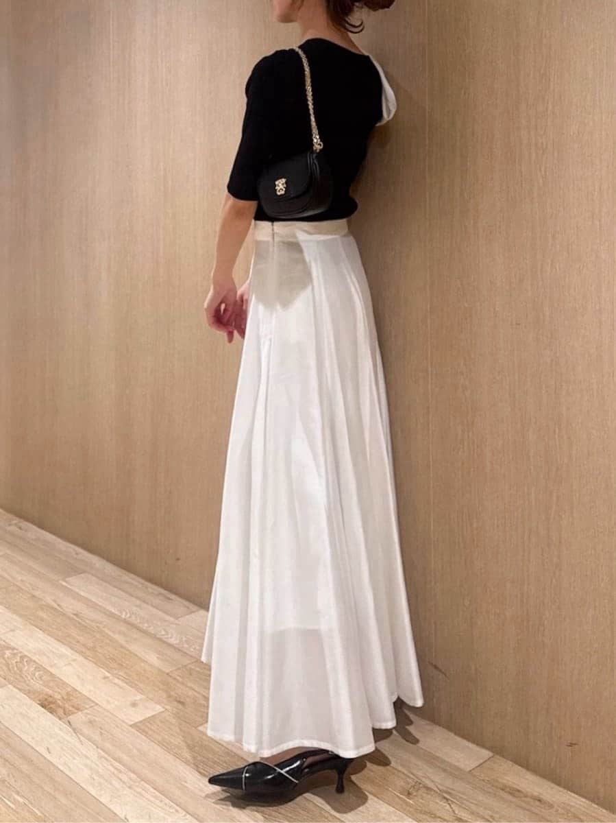 ブラック系のパンプス、ブラック系のショルダーバッグ、ブラック系のニット/セーターを着用したレディースの春コーディネートの2枚目の写真