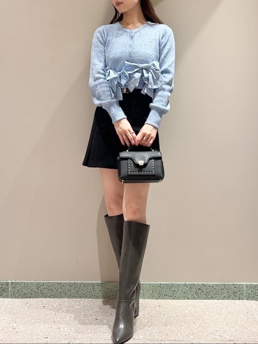 ブルー系のニット/セーター、ブラック系のスカート、ブラック系のショルダーバッグを着用したレディースの秋コーディネートの2枚目の写真