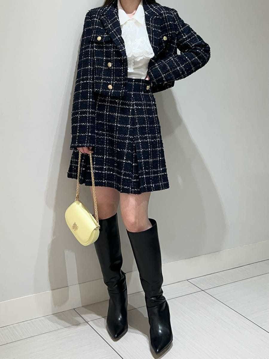 ブラック系のブーツ、ブルー系のテーラードジャケット、ブルー系のスカートを着用したレディースの春コーディネートの3枚目の写真