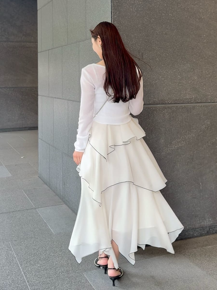 ホワイト系のワンピース、ブラック系のパンプス、イエロー系のショルダーバッグを着用したレディースの冬コーディネートの3枚目の写真