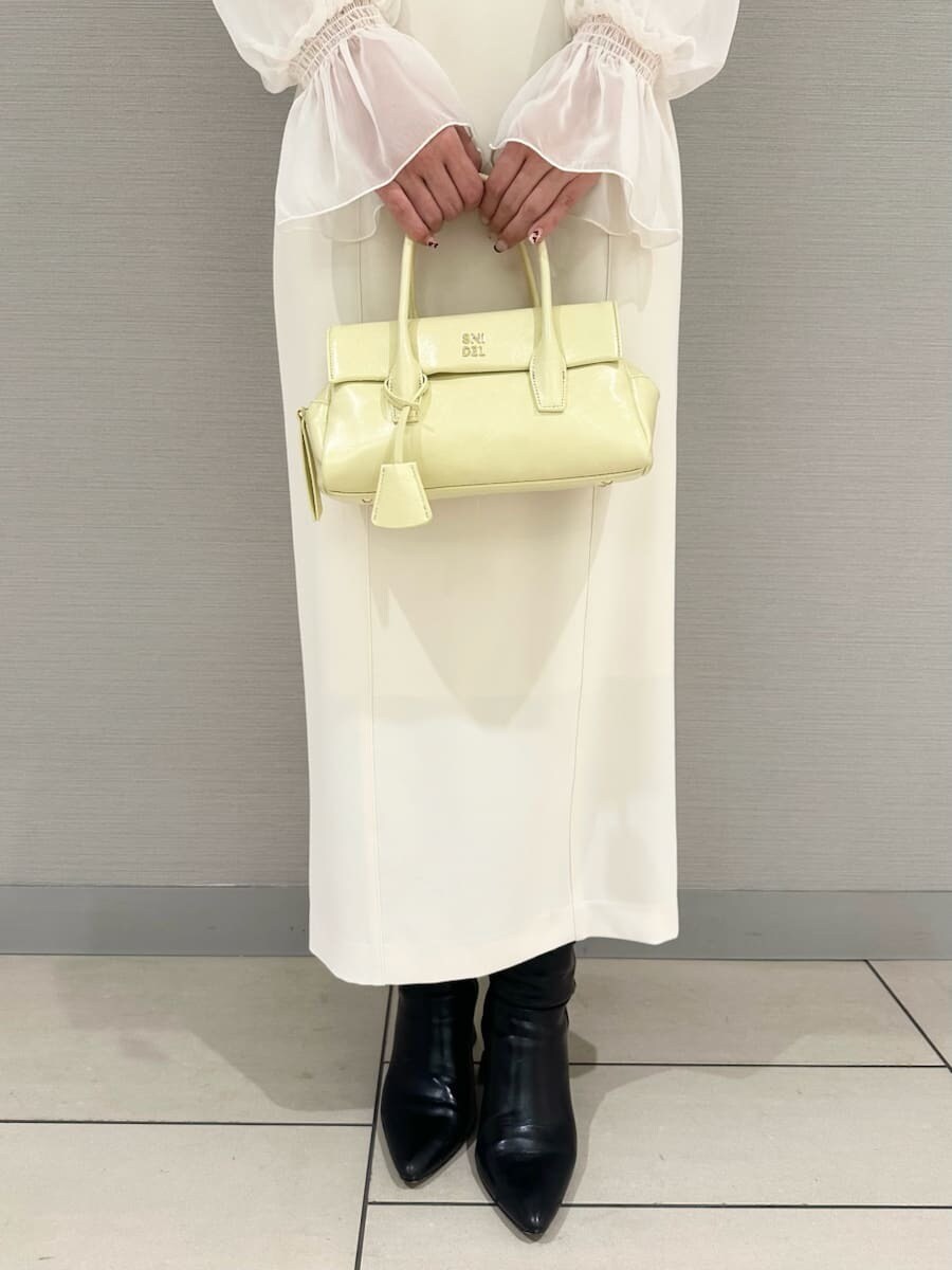 ホワイト系のスカート、ホワイト系のニット/セーター、イエロー系のボストンバッグを着用したレディースの冬コーディネートの5枚目の写真