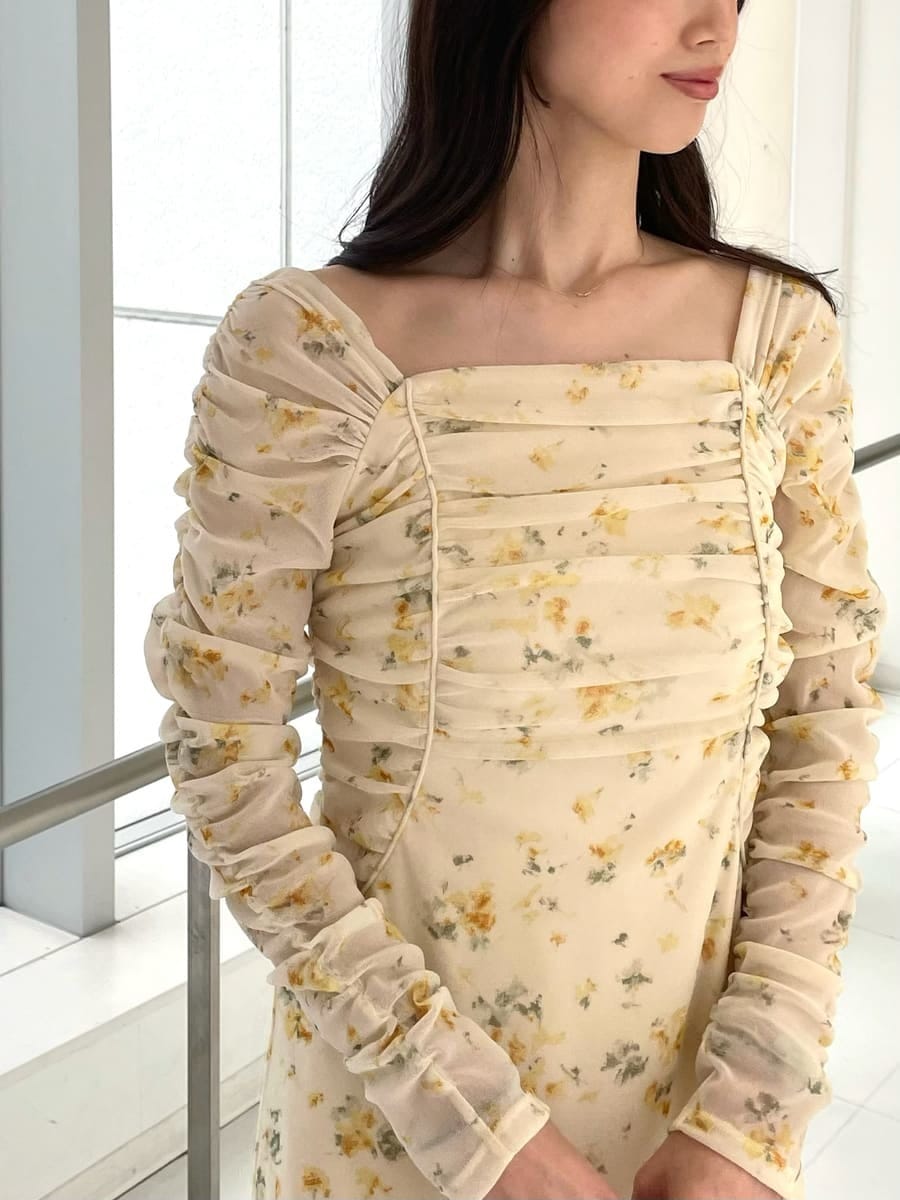 イエロー系のワンピース、ベージュ系のトレンチコート、イエロー系のボストンバッグを着用したレディースの冬コーディネートの6枚目の写真