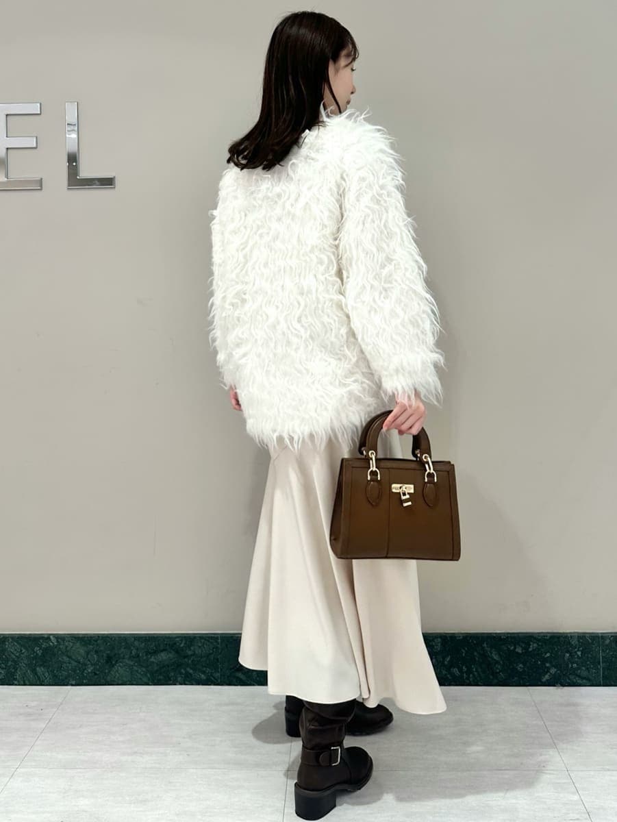 ホワイト系のワンピース、ホワイト系のカーディガン/ボレロ、ブラウン系のハンドバッグを着用したレディースの秋コーディネートの5枚目の写真