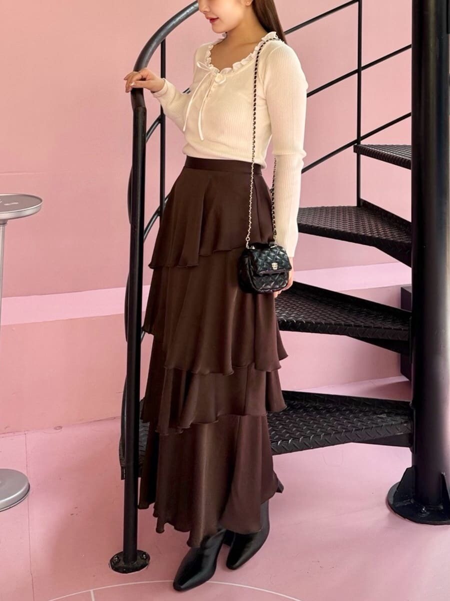 ホワイト系のニット/セーター、ブラウン系のスカート、ブラック系のブーツを着用したレディースの秋コーディネートの5枚目の写真