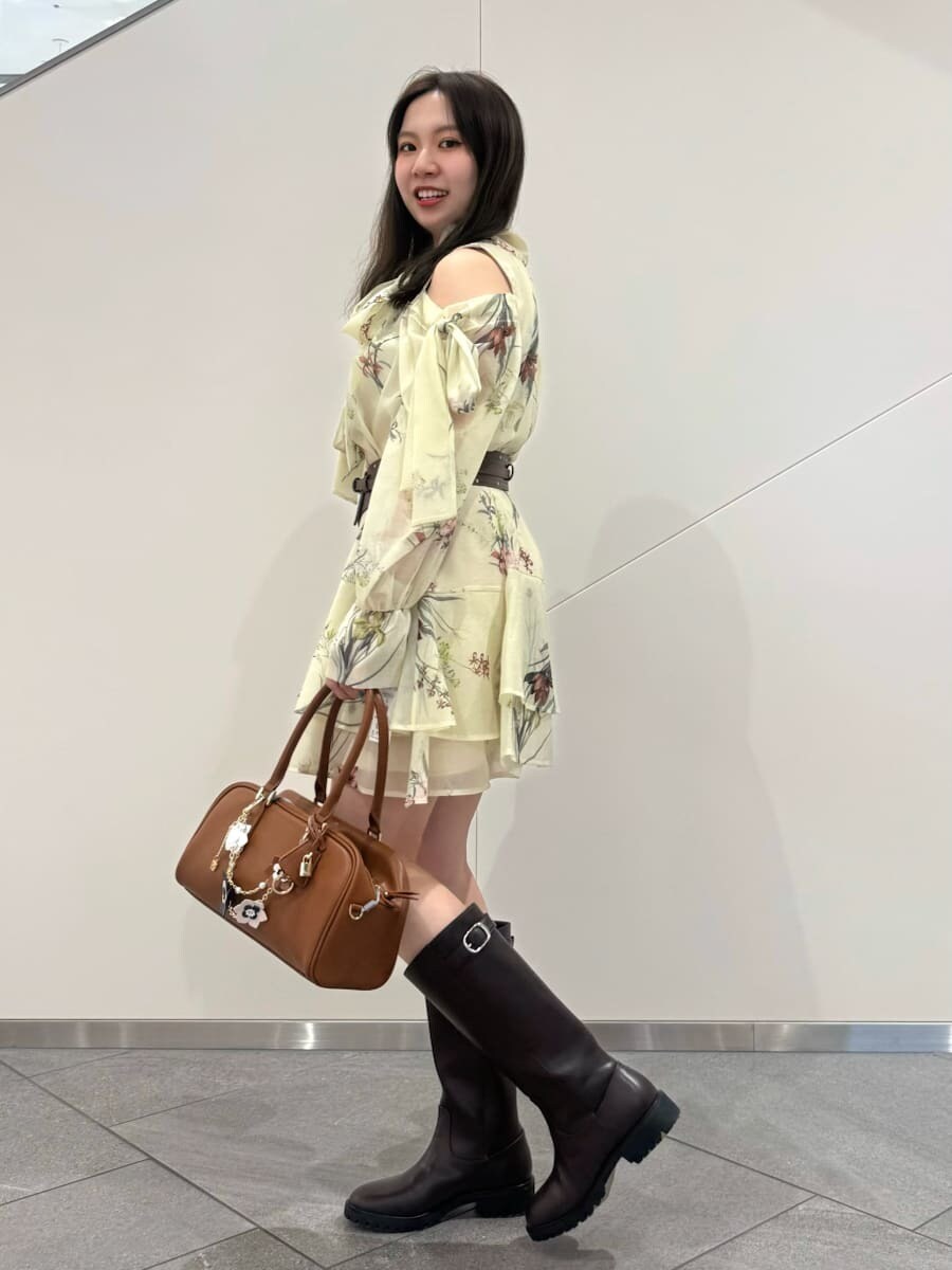 ブルー系のワンピース、イエロー系のボストンバッグ、ブラウン系のベルトを着用したレディースの冬コーディネートの2枚目の写真