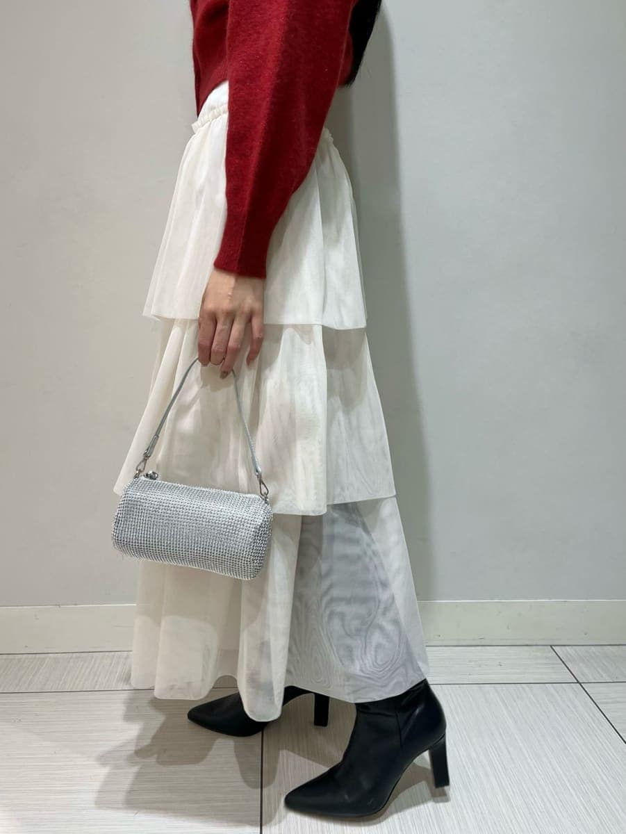 ブラック系のブーツ、ホワイト系のスカート、レッド系のカーディガン/ボレロを着用したレディースの冬コーディネートの7枚目の写真