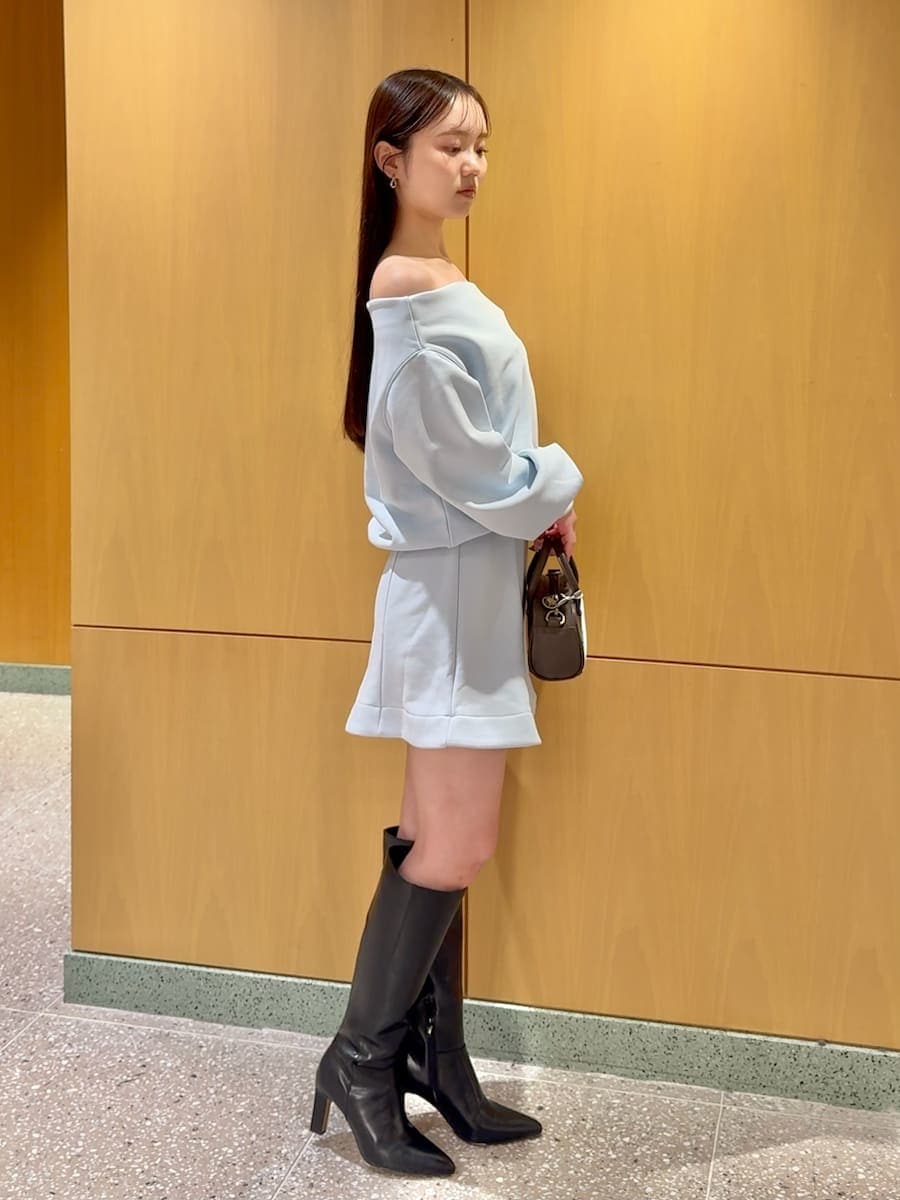 ブラック系のブーツ、ホワイト系のダウンジャケット/コート、ブルー系のワンピースを着用したレディースの冬コーディネートの5枚目の写真