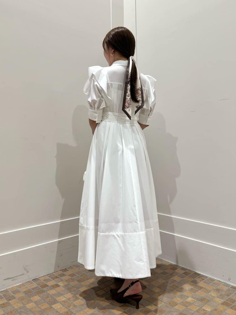 ブルー系のテーラードジャケット、ホワイト系のワンピース、ブラウン系のパンプスを着用したレディースの冬コーディネートの4枚目の写真