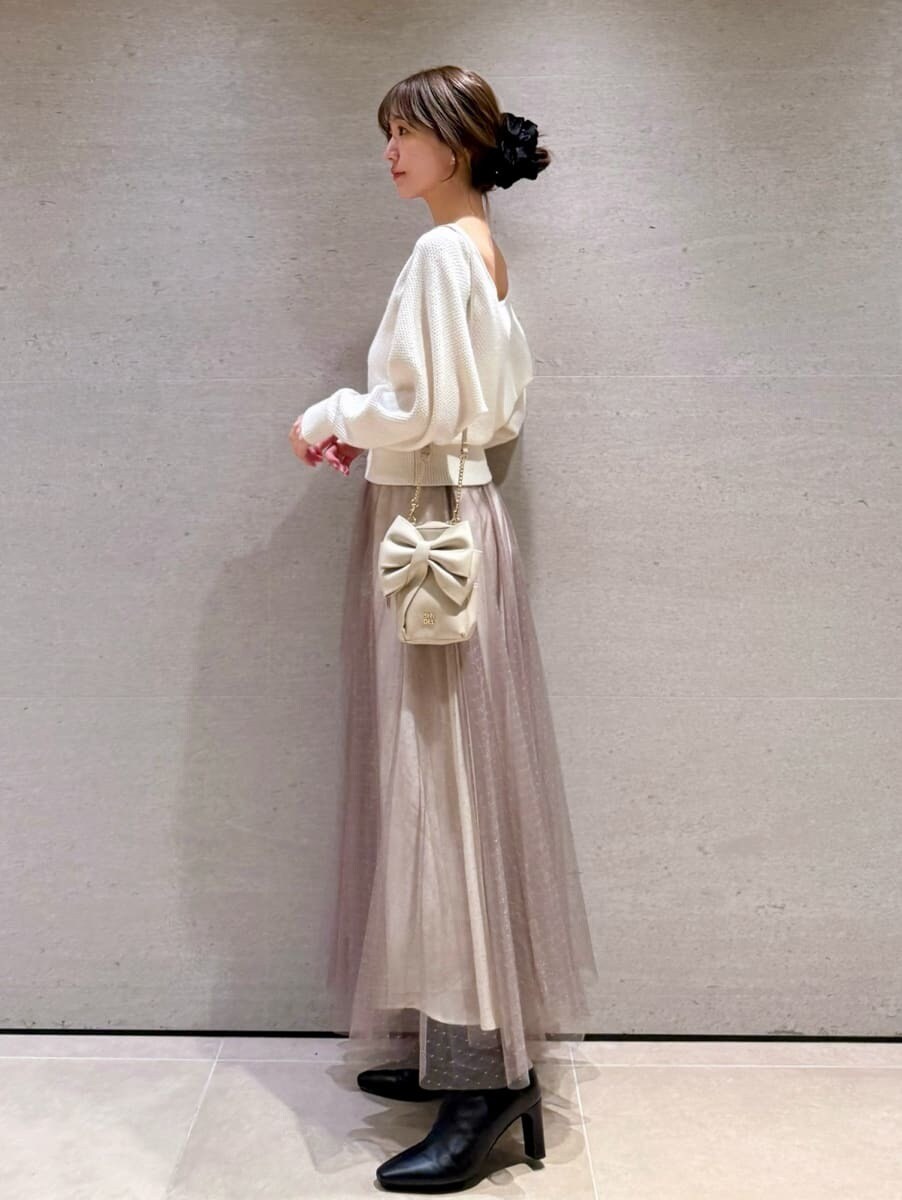 ブラック系のブーツ、ホワイト系のワンピース、グリーン系のチェスターコートを着用したレディースの秋コーディネートの5枚目の写真