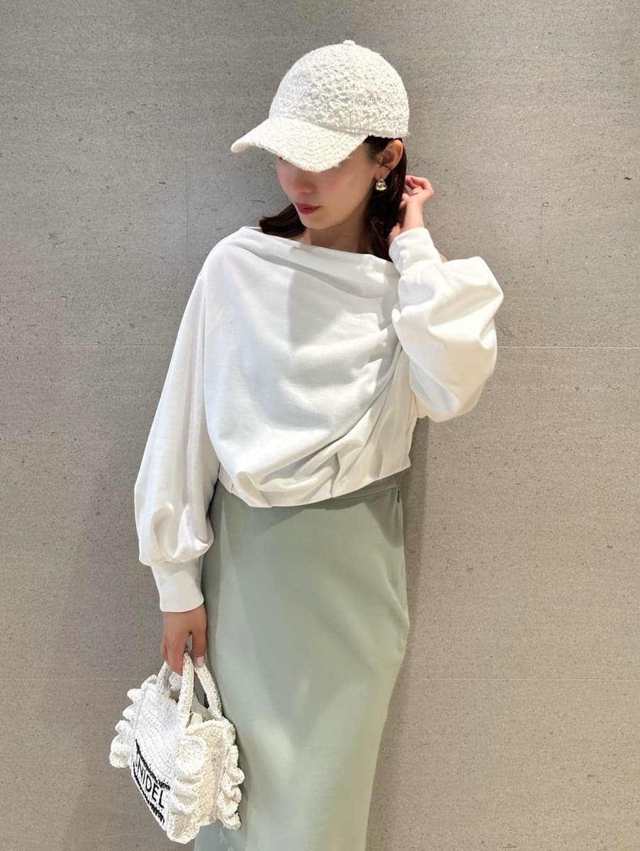 グリーン系のスカート、ホワイト系のスウェット、ホワイト系のショルダーバッグを着用したレディースの春コーディネートの5枚目の写真