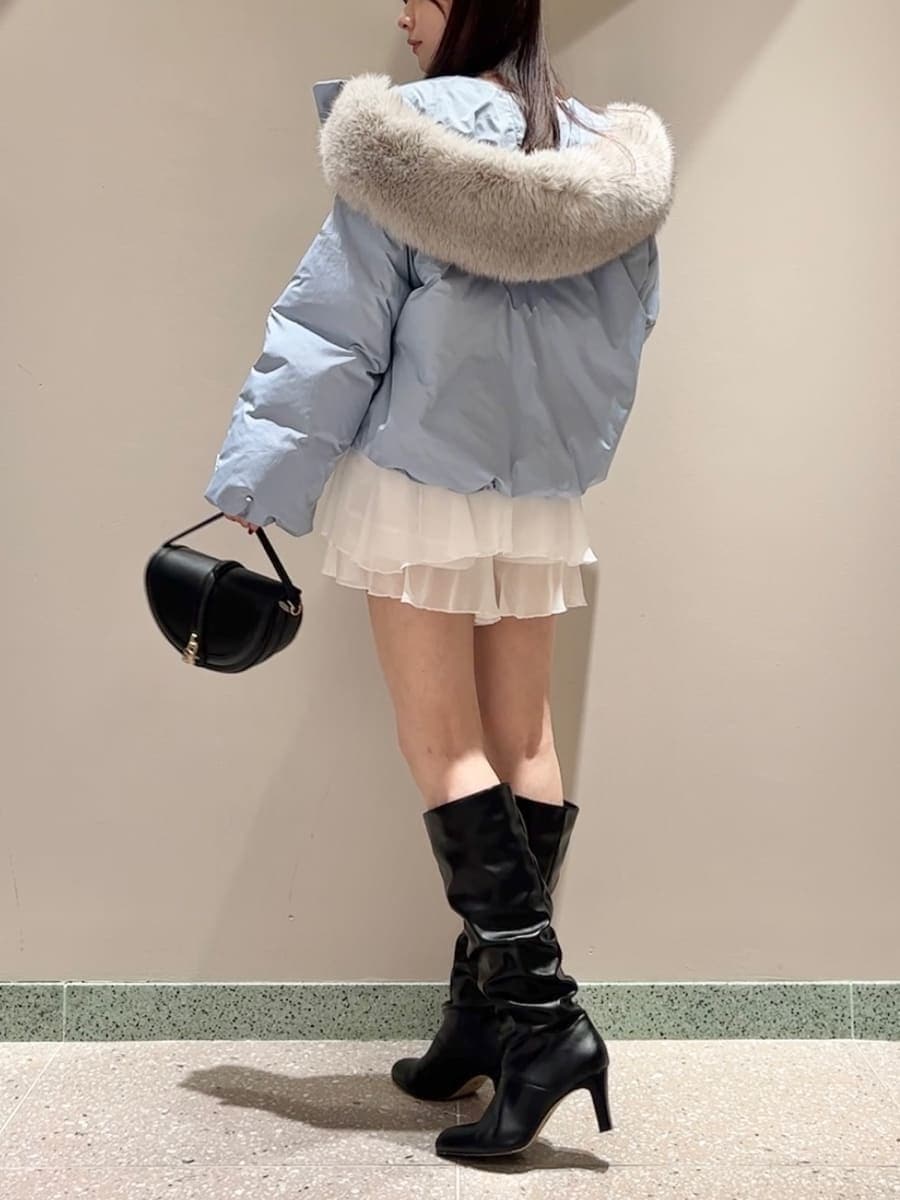 ブラック系のハンドバッグ、ブルー系のダウンジャケット/コート、ホワイト系のその他パンツを着用したレディースの秋コーディネートの3枚目の写真