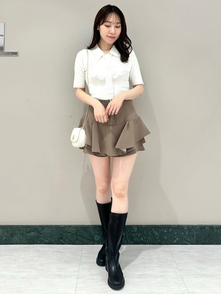 ホワイト系のニット/セーター、ホワイト系のショルダーバッグ、ブラウン系のその他パンツを着用したレディースの春コーディネートの2枚目の写真