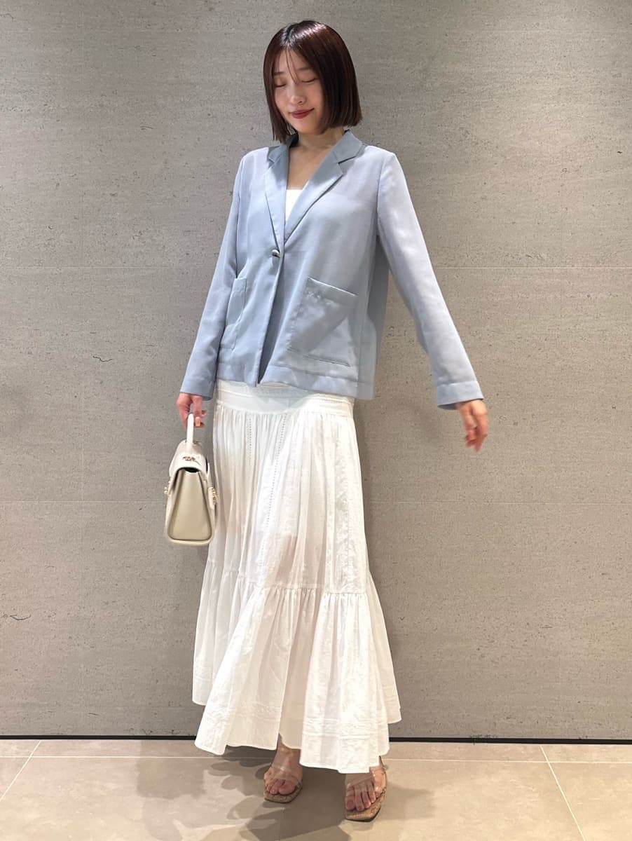 ブルー系のテーラードジャケット、ホワイト系のスカート、ホワイト系のショルダーバッグを着用したレディースの夏コーディネートの3枚目の写真